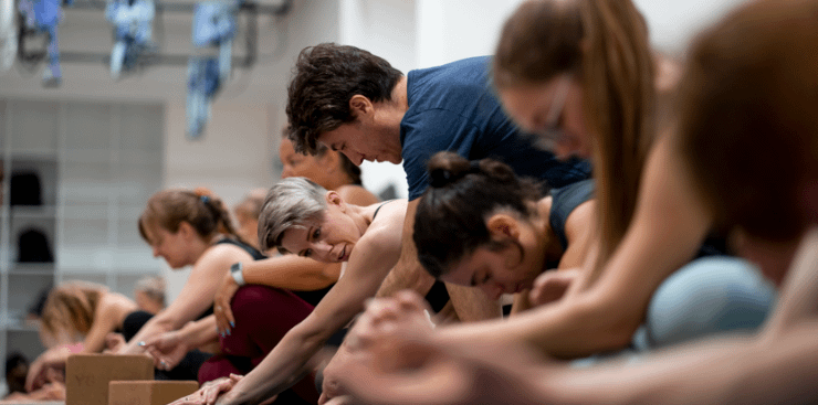 Camilo ayudando a alumnos en su postura de yoga en el estudio de YOGABODY de la Sagrada Familia